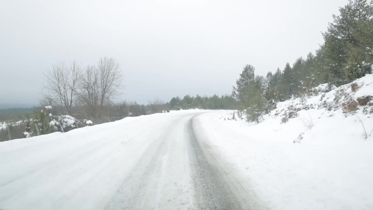 在塞尔维亚大雪纷飞的乡村路上开车视频素材