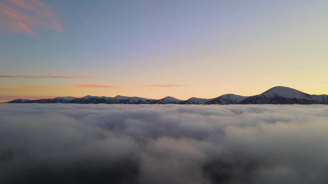 空中鸟瞰图，充满活力的日出在白色浓雾和遥远的喀尔巴阡山脉的黑色山峰在地平线上视频素材