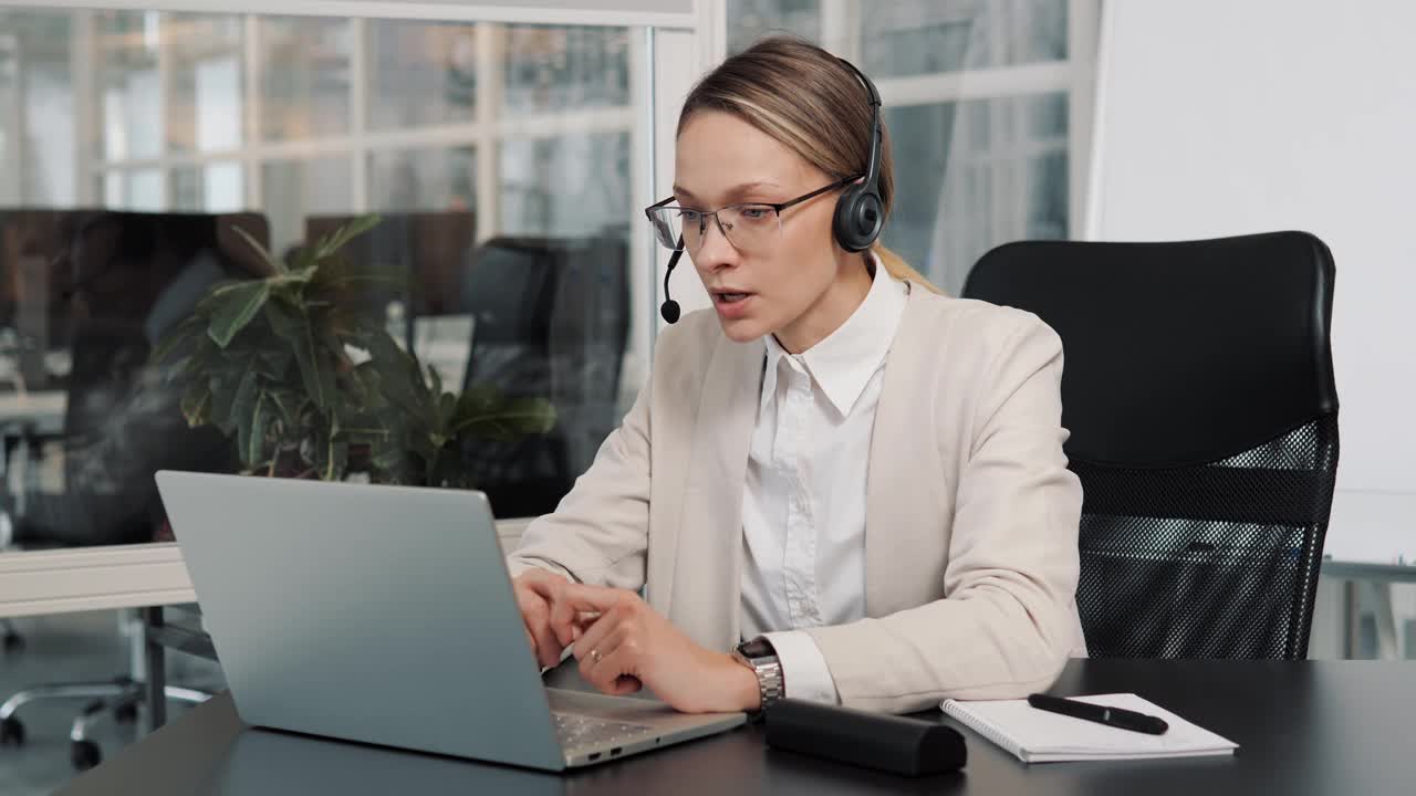 女高管戴着耳机在笔记本电脑上视频通话。女商人网络研讨会发言人流直播网络培训。呼叫中心座席、服务支持经理通过网络摄像头与远程客户通话。视频素材