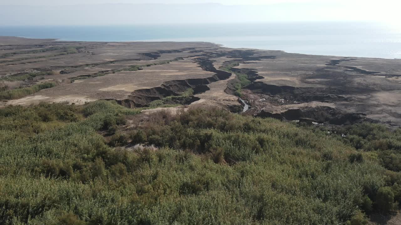 在阳光明媚的日子里，航拍的溪流在海岸线流动，无人机在水面上平移-风景秀丽的景观视频素材