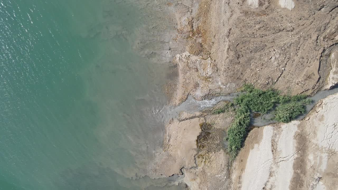 空中拍摄的小溪在阳光明媚的一天在海岸线流动，无人机平移水-死海，以色列视频素材