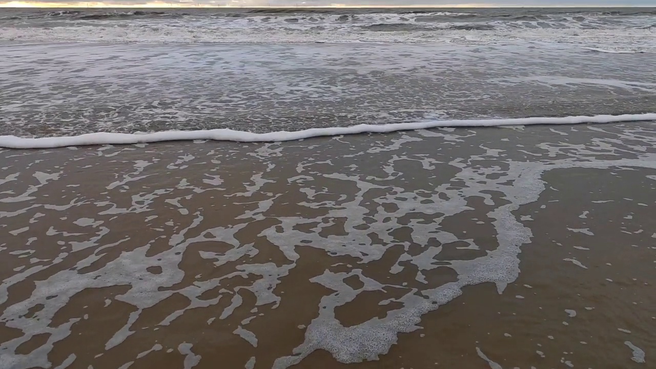 在荷兰北部的Egmond aan zee海岸上的北海倾斜镜头，在寒冷的秋冬季节视频下载