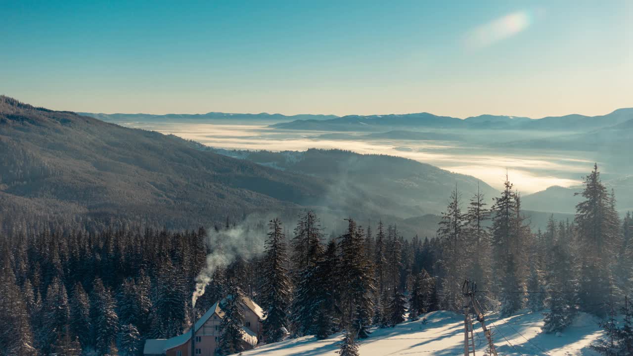 山区冬季景观。雾从山谷中流过，烟从小木屋的烟囱里冒出来，冰雪从冷杉树上飘落，乌鸦栖息在树上。德拉戈布拉的延时视频视频素材