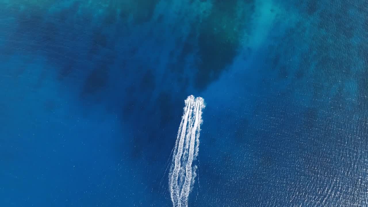 水上摩托艇在海洋中飞过珊瑚礁的鸟瞰图视频素材