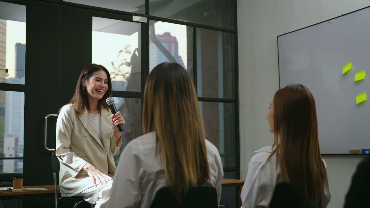 漂亮的年轻女子在会议室和团队谈话。视频素材