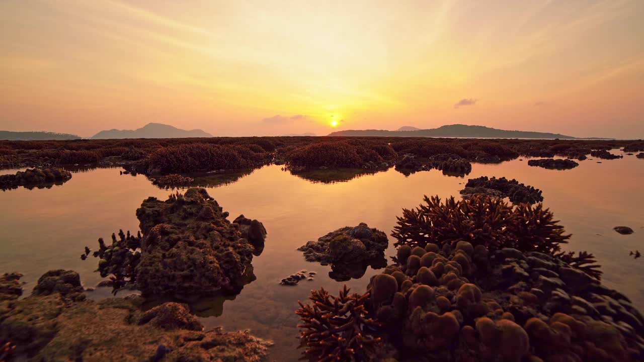 低潮时的珊瑚礁，在海上美丽的光日出在热带岛屿在泰国普吉岛令人惊叹的自然景观，令人惊叹的海景背景视频素材