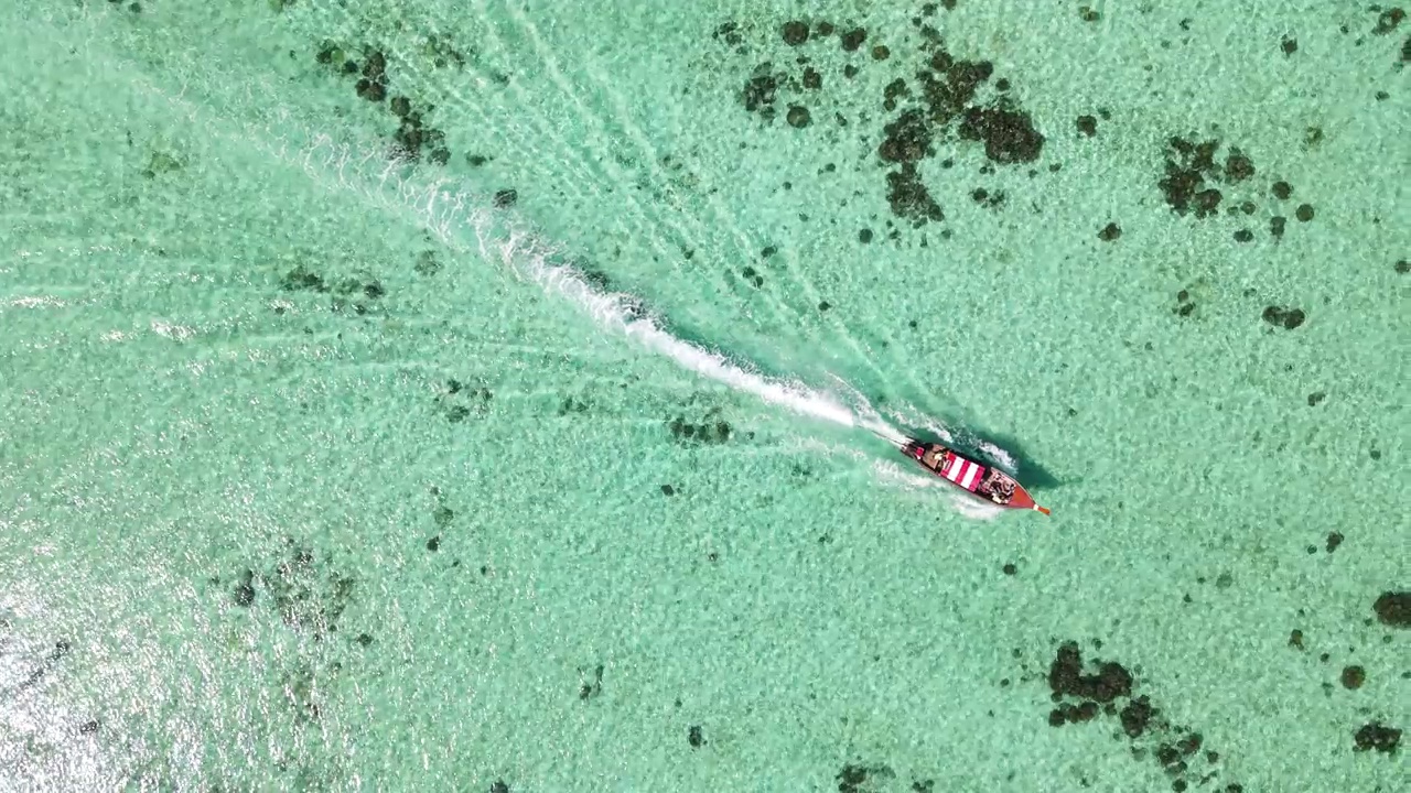 当旅游船驶过泰国南部的里佩岛时，飞越水晶般清澈的海洋和珊瑚视频素材