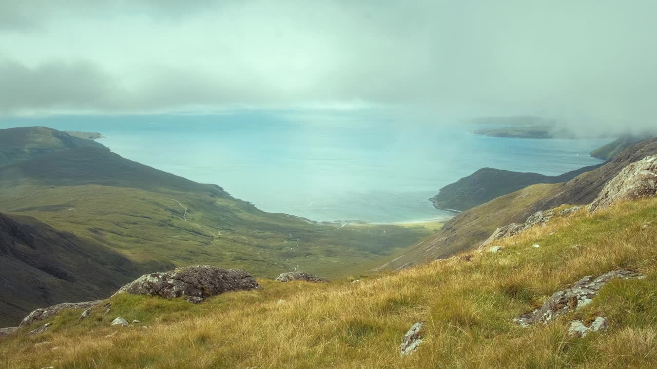 一位徒步旅行者在山顶欣赏海湾的壮丽景色视频下载