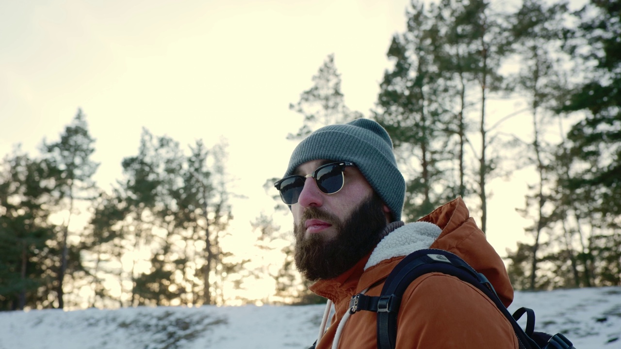 背着背包的男人在山上徒步旅行。天气寒冷，山上下雪。冬季徒步旅行。视频素材