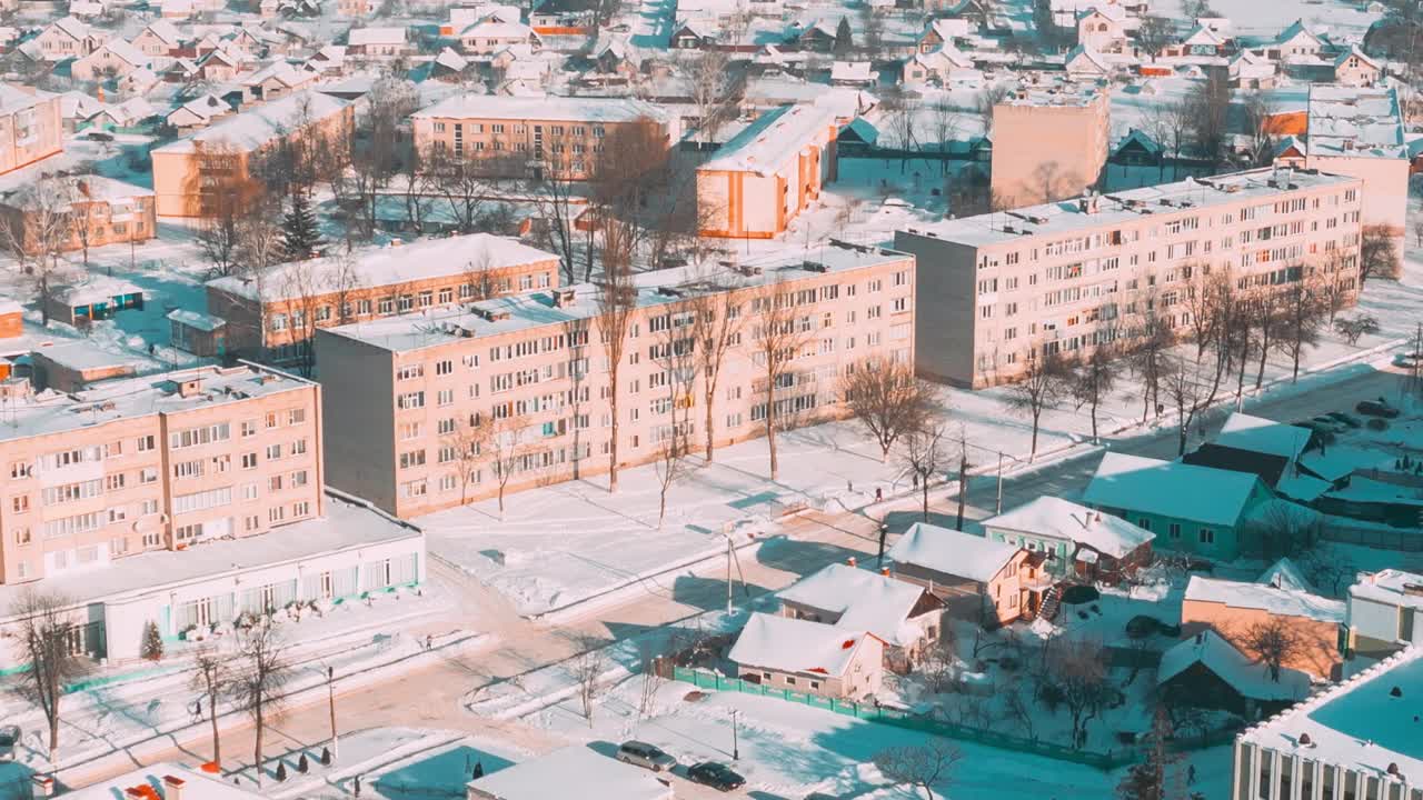 阳光明媚的冬日时光流逝。鸟瞰小镇村庄城市景观天际线交通在雪景。住宅鸟瞰图。时间流逝视频素材