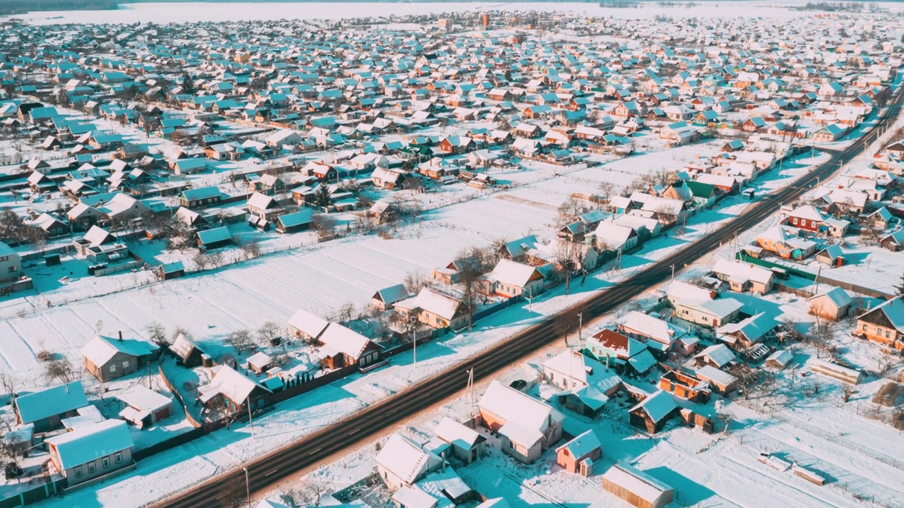 阳光明媚的冬日时光流逝。鸟瞰小镇村庄城市景观天际线交通在雪景。住宅鸟瞰图。时间流逝视频素材