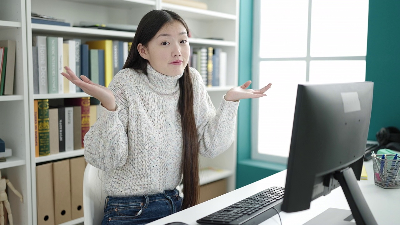 年轻的中国女学生在图书馆大学用电脑做手势视频素材