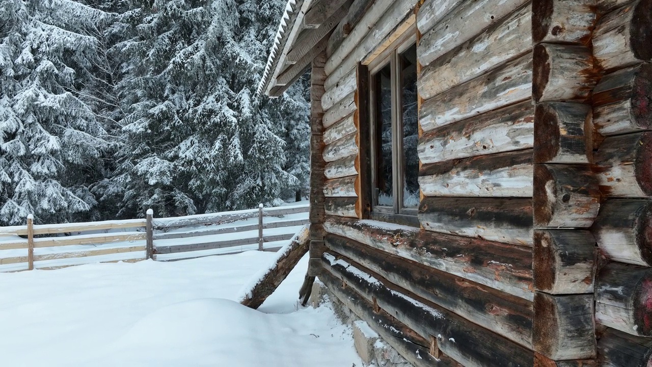 壮丽的山区冬季景观，冷杉林中幽静的小木屋在下雪时完全被雪覆盖。视频素材