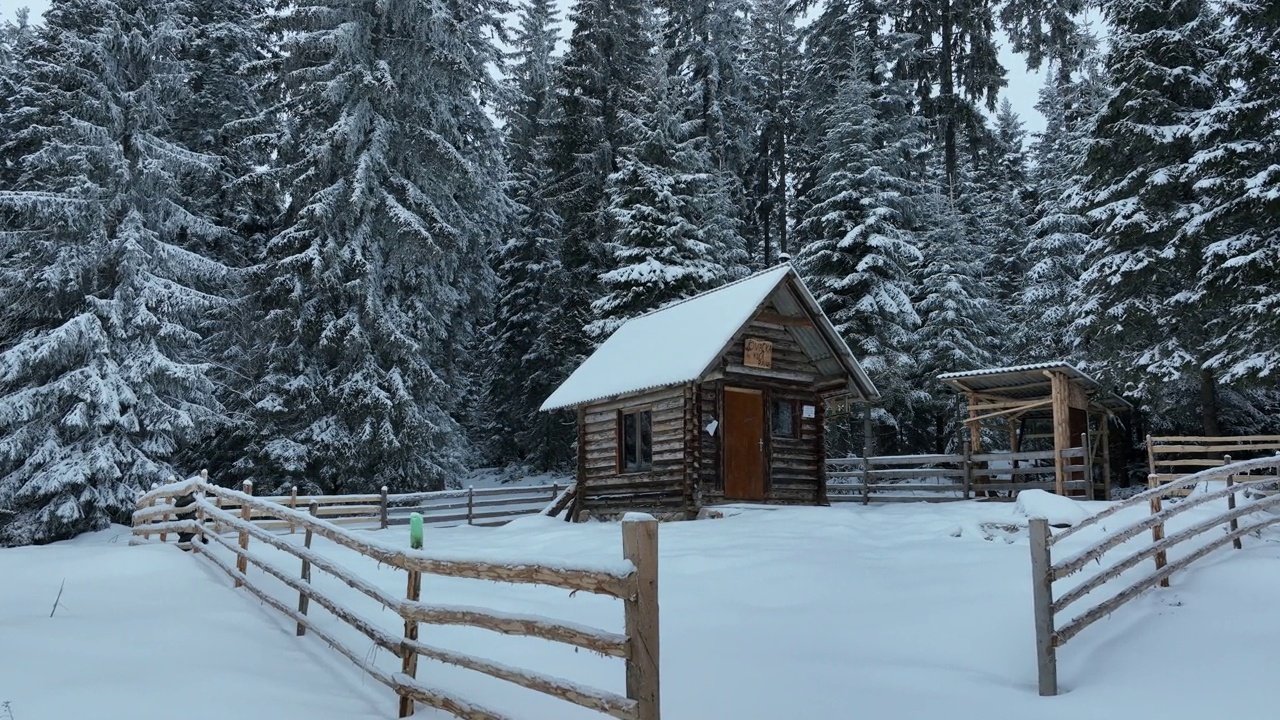 壮丽的山区冬季景观，冷杉林中幽静的小木屋在下雪时完全被雪覆盖。视频素材