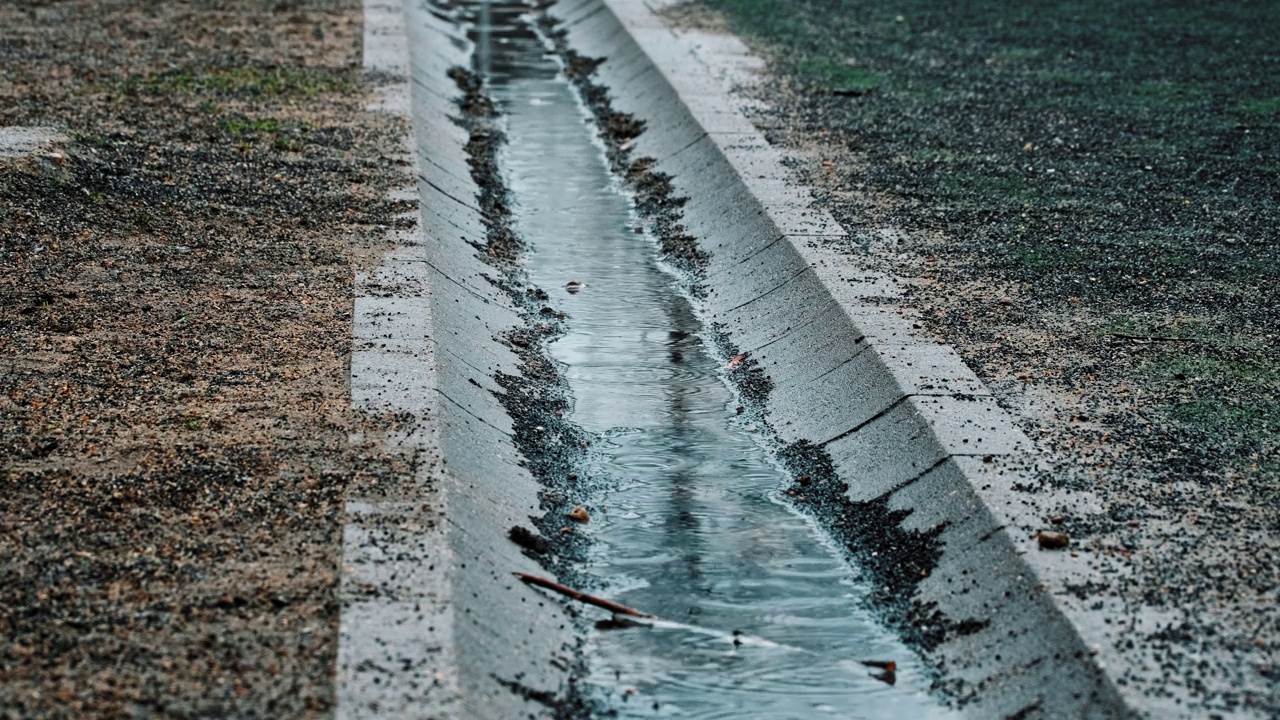 混凝土沟渠在寒冷阴天充满雨水视频素材