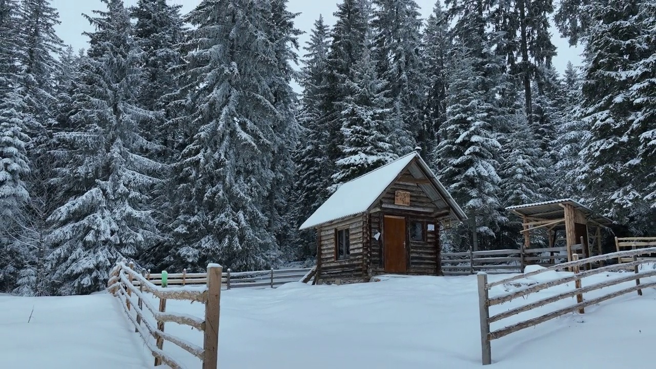 壮丽的山区冬季景观，冷杉林中幽静的小木屋在下雪时完全被雪覆盖。视频素材