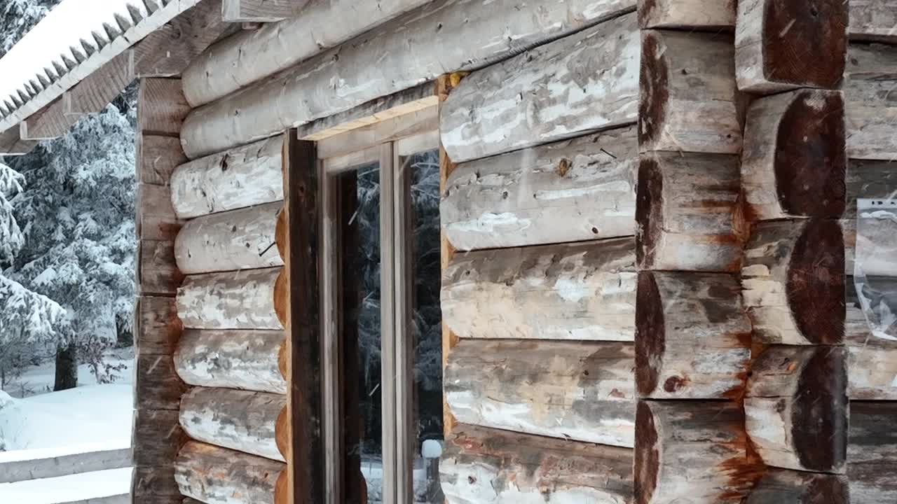 壮丽的山区冬季景观，冷杉林中幽静的小木屋在下雪时完全被雪覆盖。视频素材