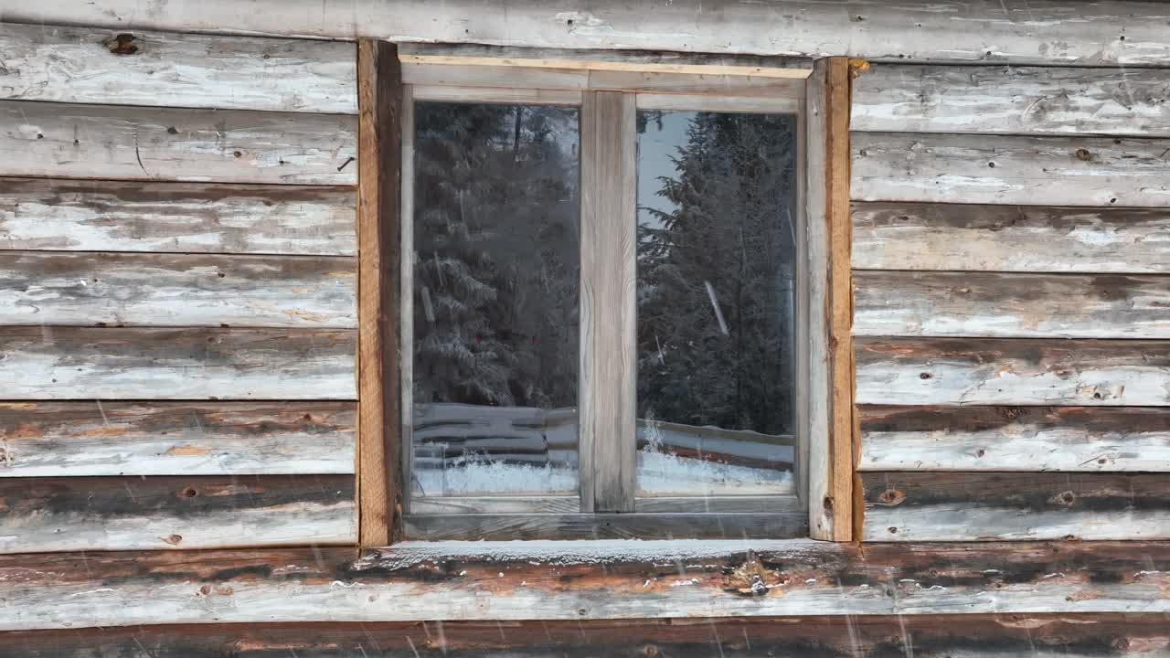 壮丽的山区冬季景观，冷杉林中幽静的小木屋在下雪时完全被雪覆盖。视频素材