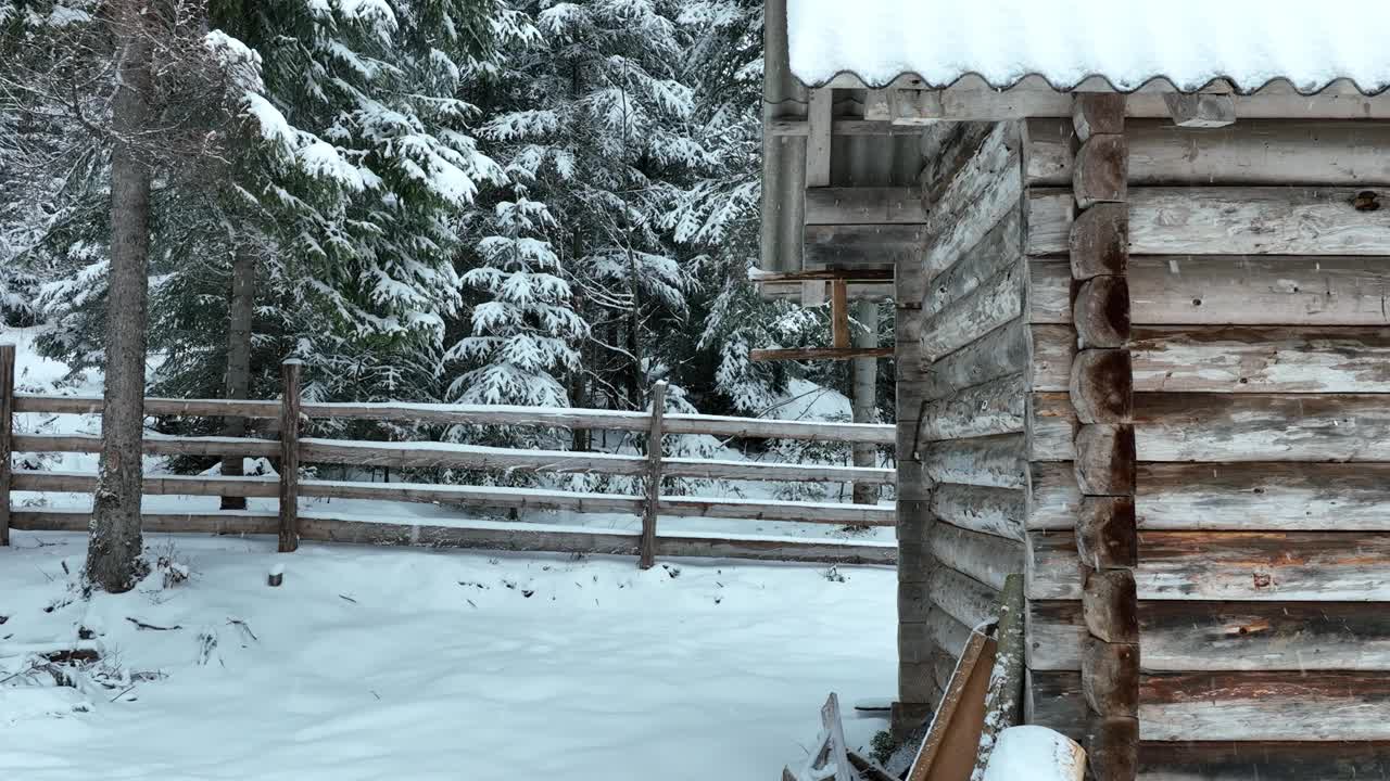 壮丽的山区冬季景观，冷杉林中幽静的小木屋在下雪时完全被雪覆盖。视频素材