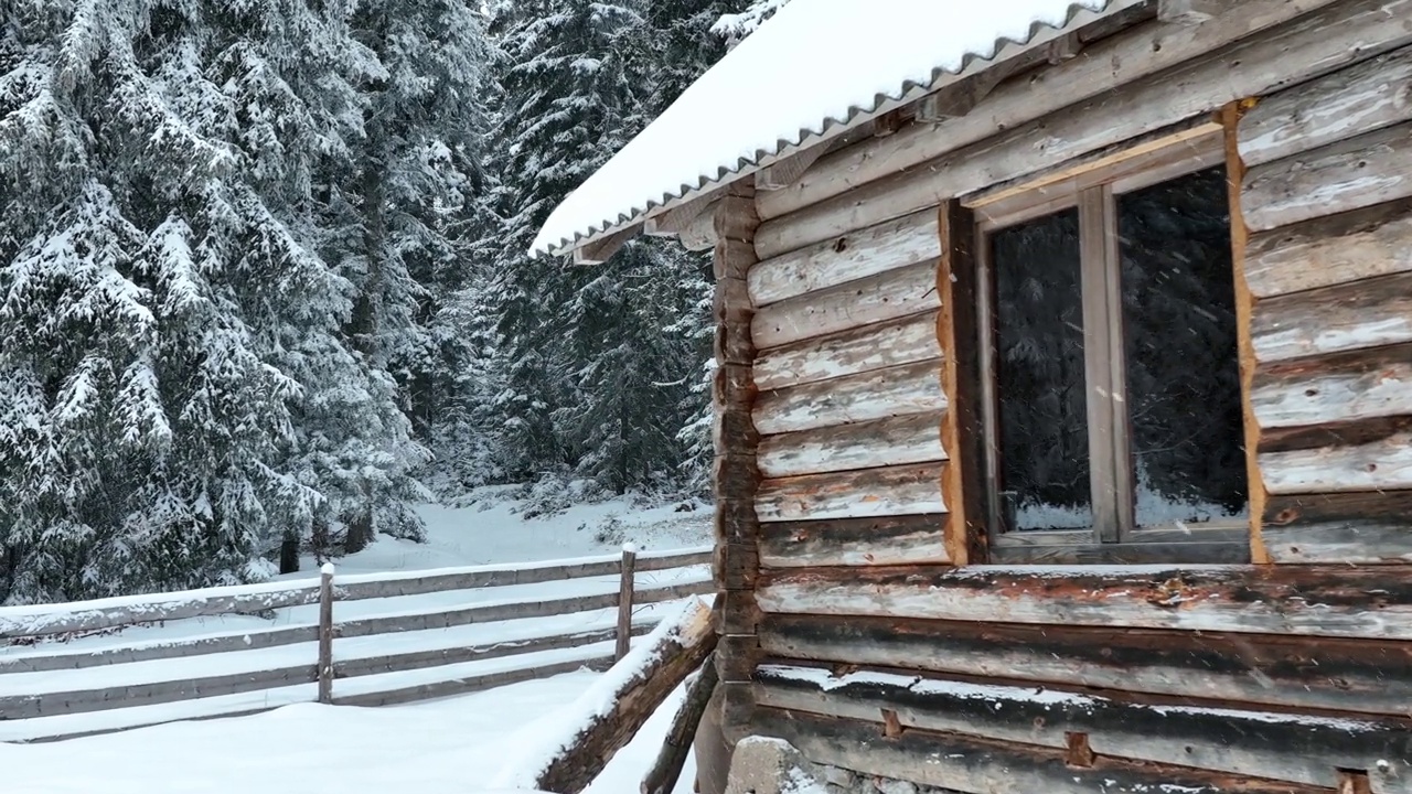 壮丽的山区冬季景观，冷杉林中幽静的小木屋在下雪时完全被雪覆盖。视频素材