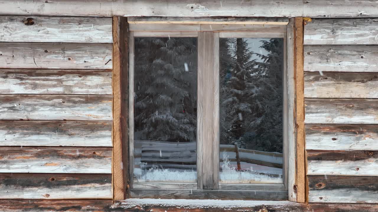 壮丽的山区冬季景观，冷杉林中幽静的小木屋在下雪时完全被雪覆盖。视频素材