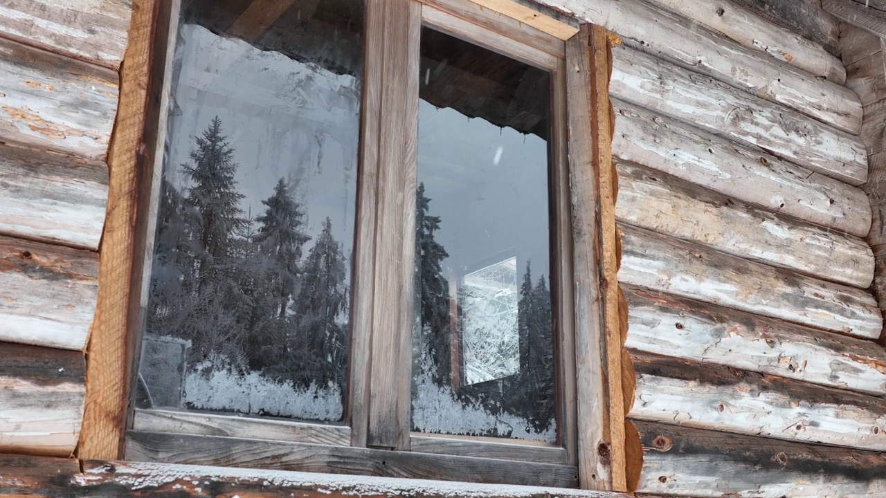 壮丽的山区冬季景观，冷杉林中幽静的小木屋在下雪时完全被雪覆盖。视频素材