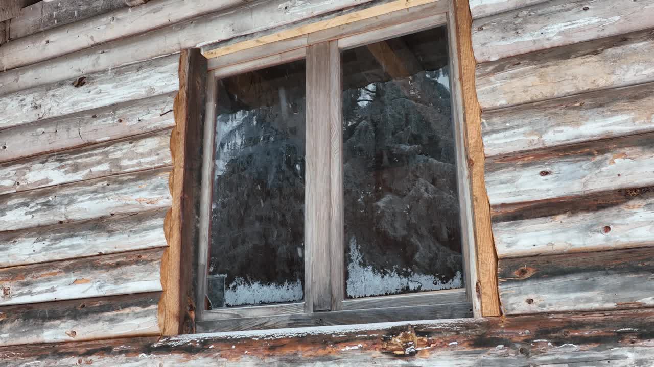 壮丽的山区冬季景观，冷杉林中幽静的小木屋在下雪时完全被雪覆盖。视频素材