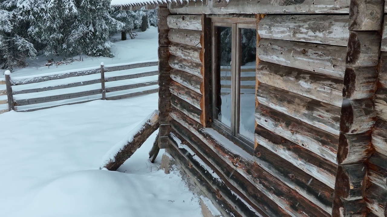 壮丽的山区冬季景观，冷杉林中幽静的小木屋在下雪时完全被雪覆盖。视频素材