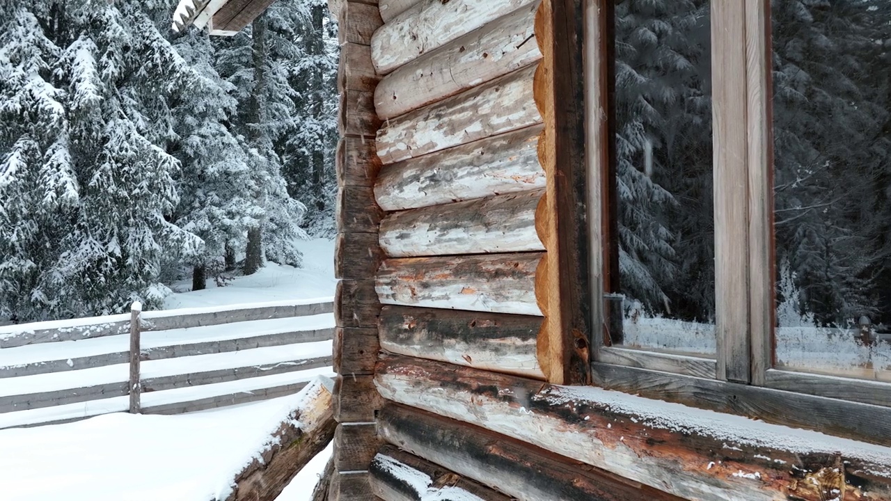 壮丽的山区冬季景观，冷杉林中幽静的小木屋在下雪时完全被雪覆盖。视频素材