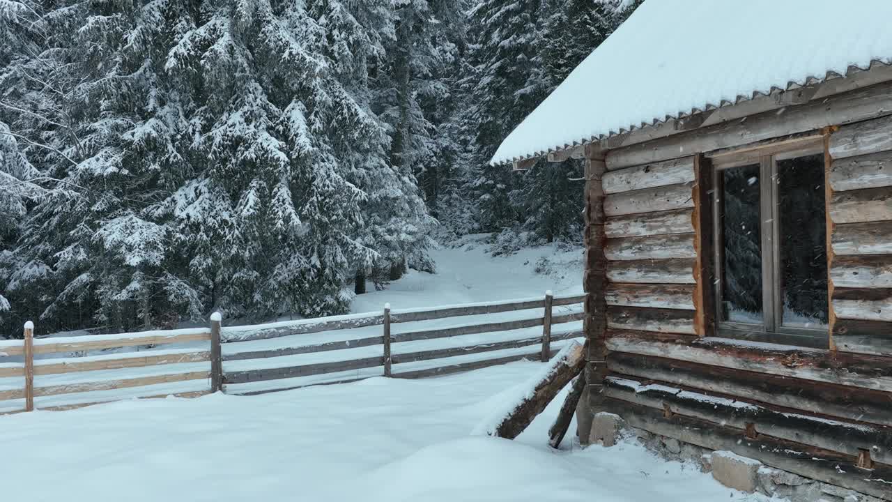 壮丽的山区冬季景观，冷杉林中幽静的小木屋在下雪时完全被雪覆盖。视频素材