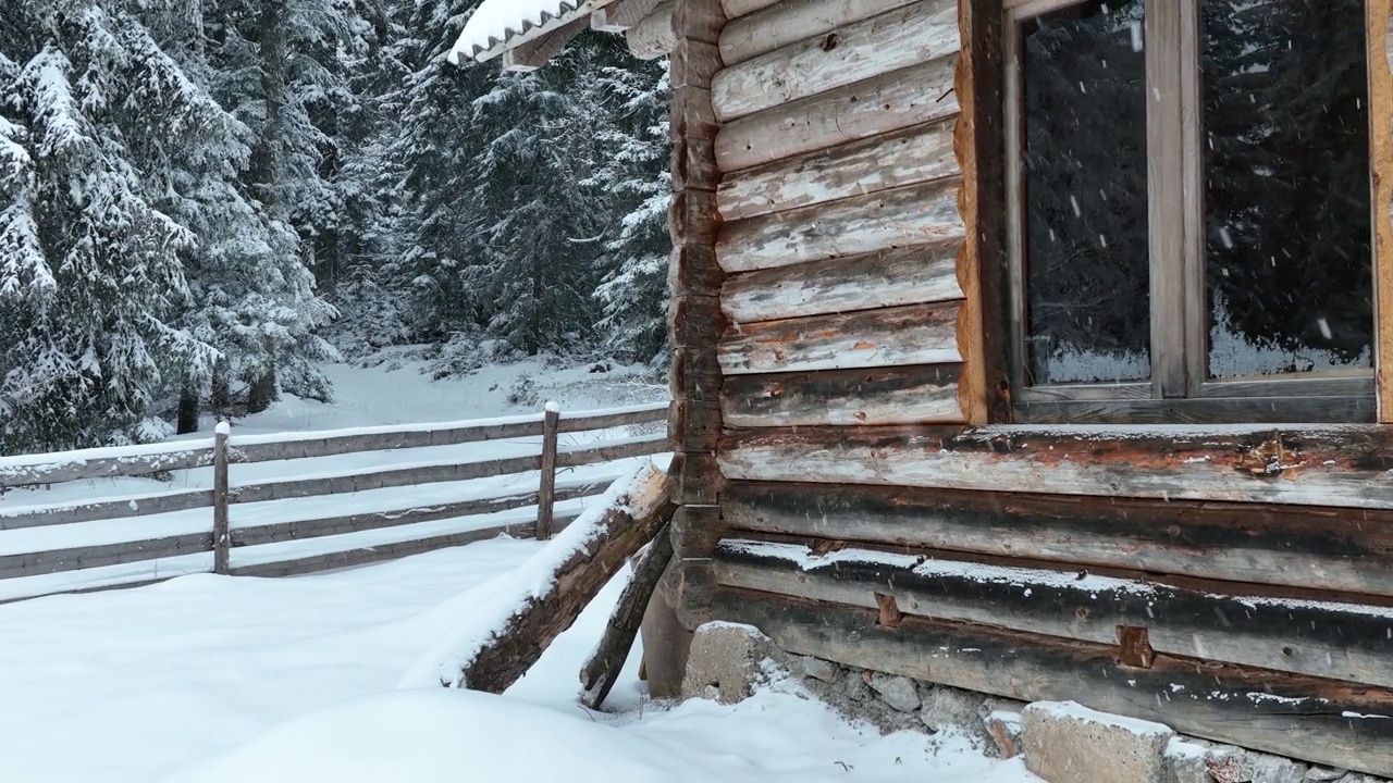 壮丽的山区冬季景观，冷杉林中幽静的小木屋在下雪时完全被雪覆盖。视频素材