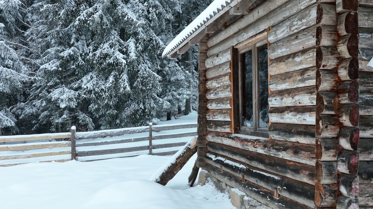 壮丽的山区冬季景观，冷杉林中幽静的小木屋在下雪时完全被雪覆盖。视频素材