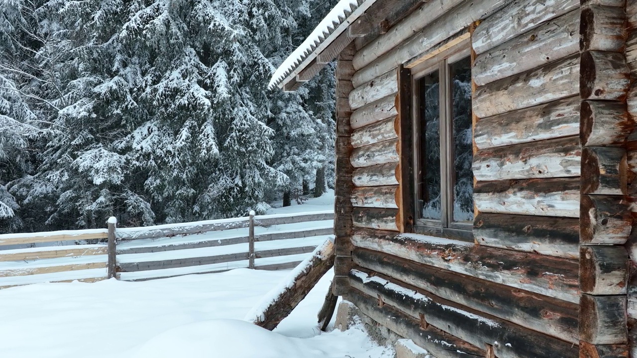 壮丽的山区冬季景观，冷杉林中幽静的小木屋在下雪时完全被雪覆盖。视频素材