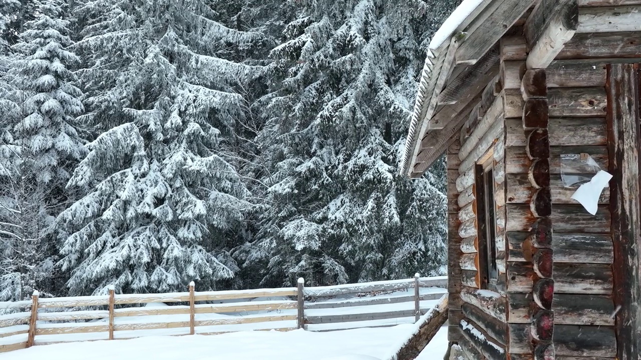 壮丽的山区冬季景观，冷杉林中幽静的小木屋在下雪时完全被雪覆盖。视频素材