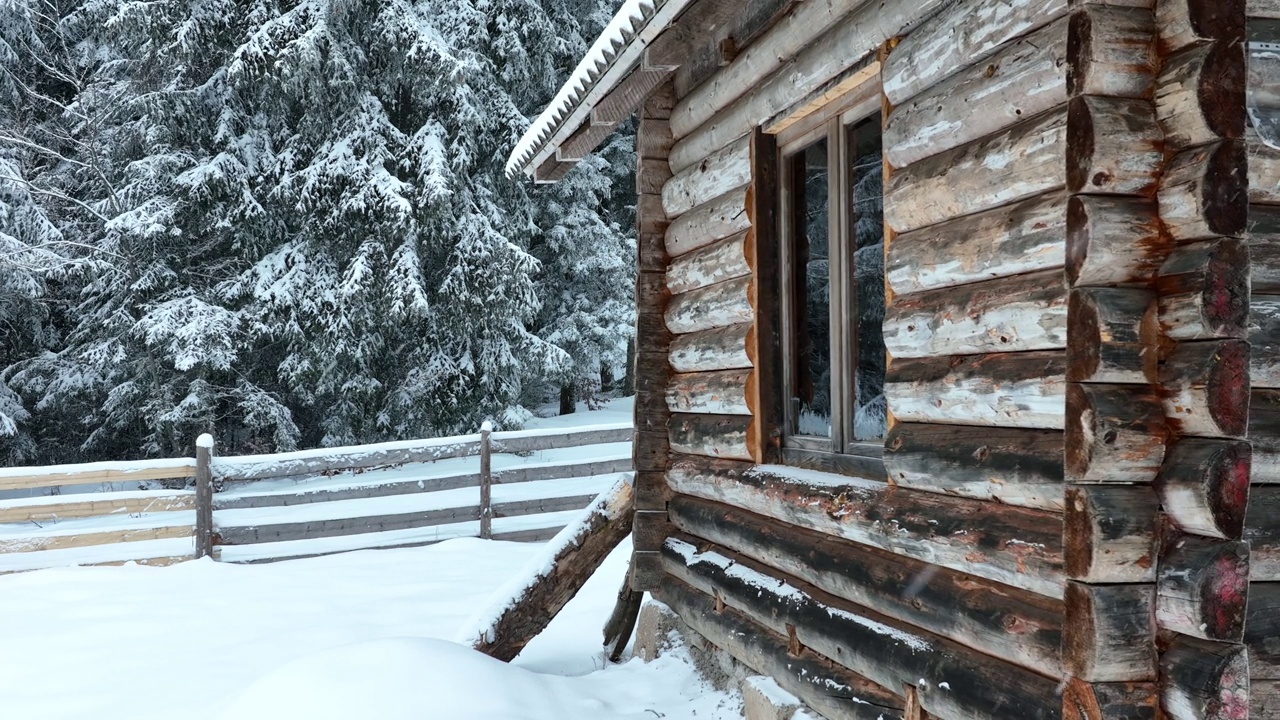 壮丽的山区冬季景观，冷杉林中幽静的小木屋在下雪时完全被雪覆盖。视频素材