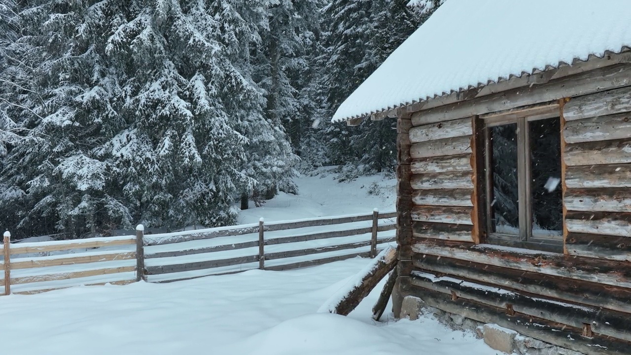 壮丽的山区冬季景观，冷杉林中幽静的小木屋在下雪时完全被雪覆盖。视频素材