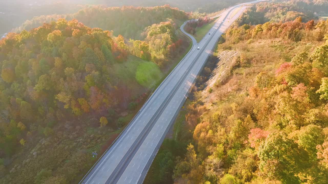 在金色的秋季，高速公路在北卡罗莱纳州通过阿巴拉契亚山脉的鸟瞰图，快速移动的卡车和汽车。州际运输概念视频素材