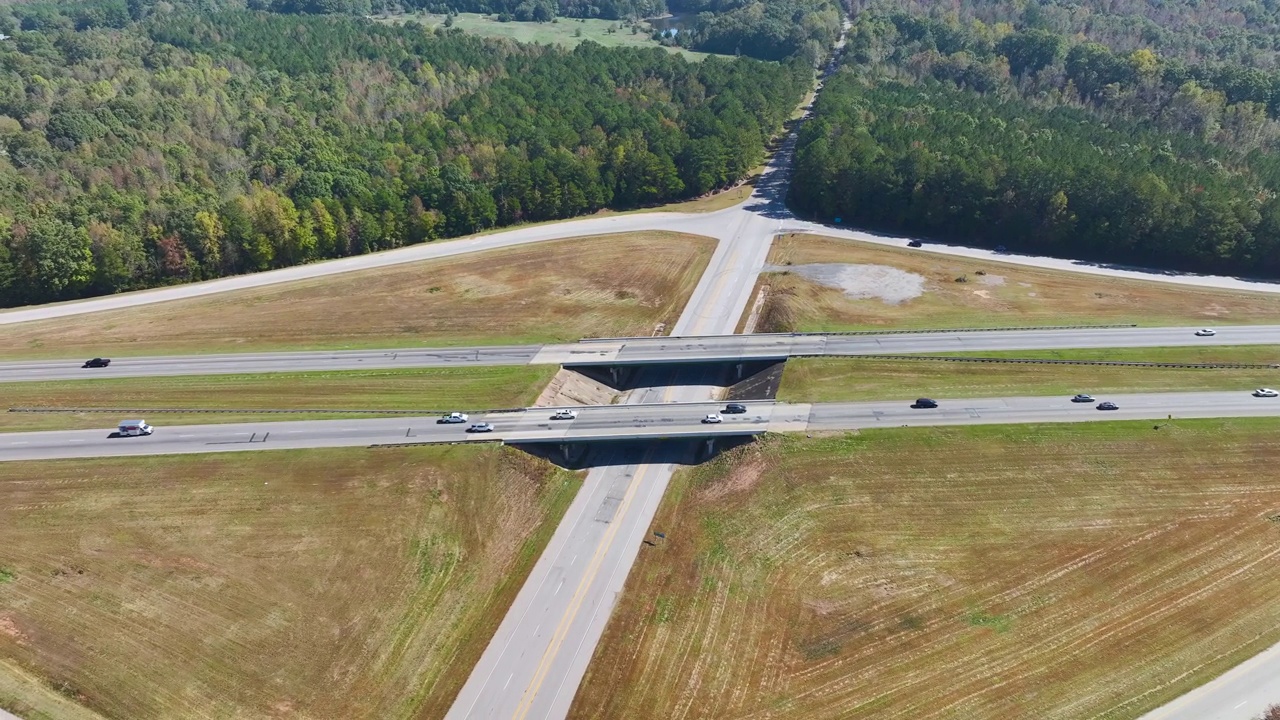 高速公路出口路口的高架视图，公路车道上有快速移动的交通汽车和卡车。美国州际交通基础设施视频素材