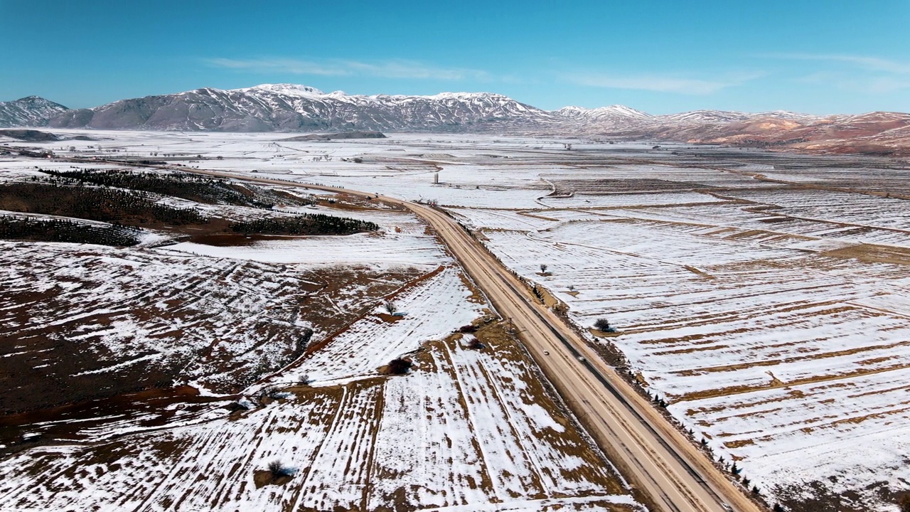 无人机拍摄的冬季雪山高速公路视频素材