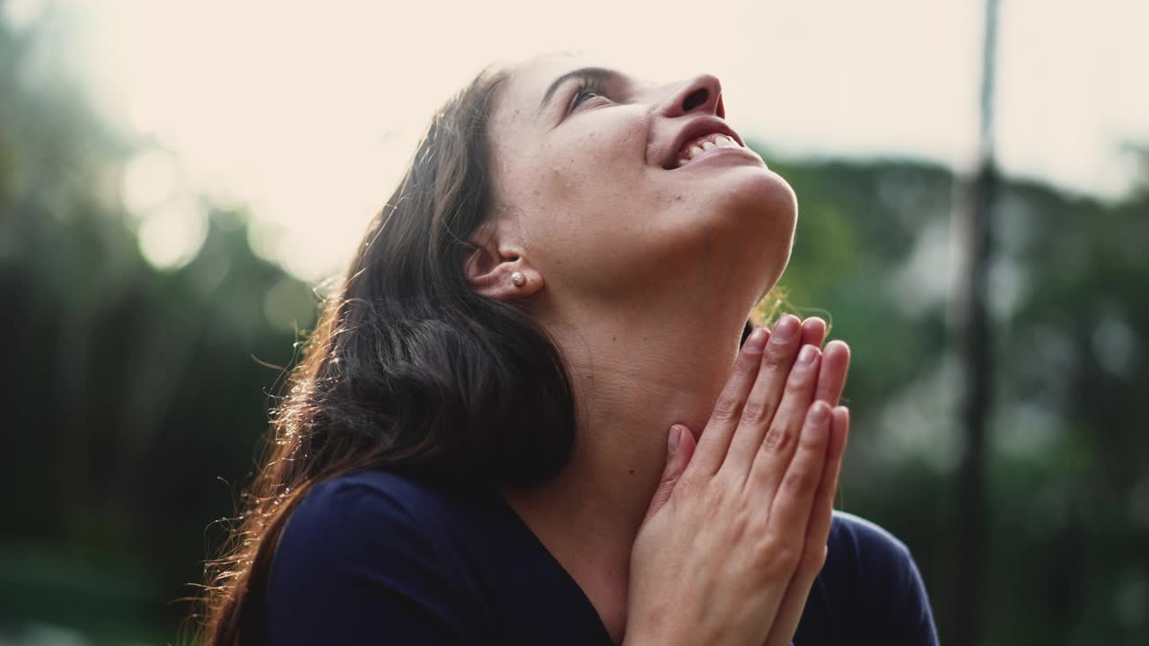 虔诚的女人在大自然的阳光下祈祷。精神上有希望的人祈祷。忠诚的女孩感觉神圣视频素材