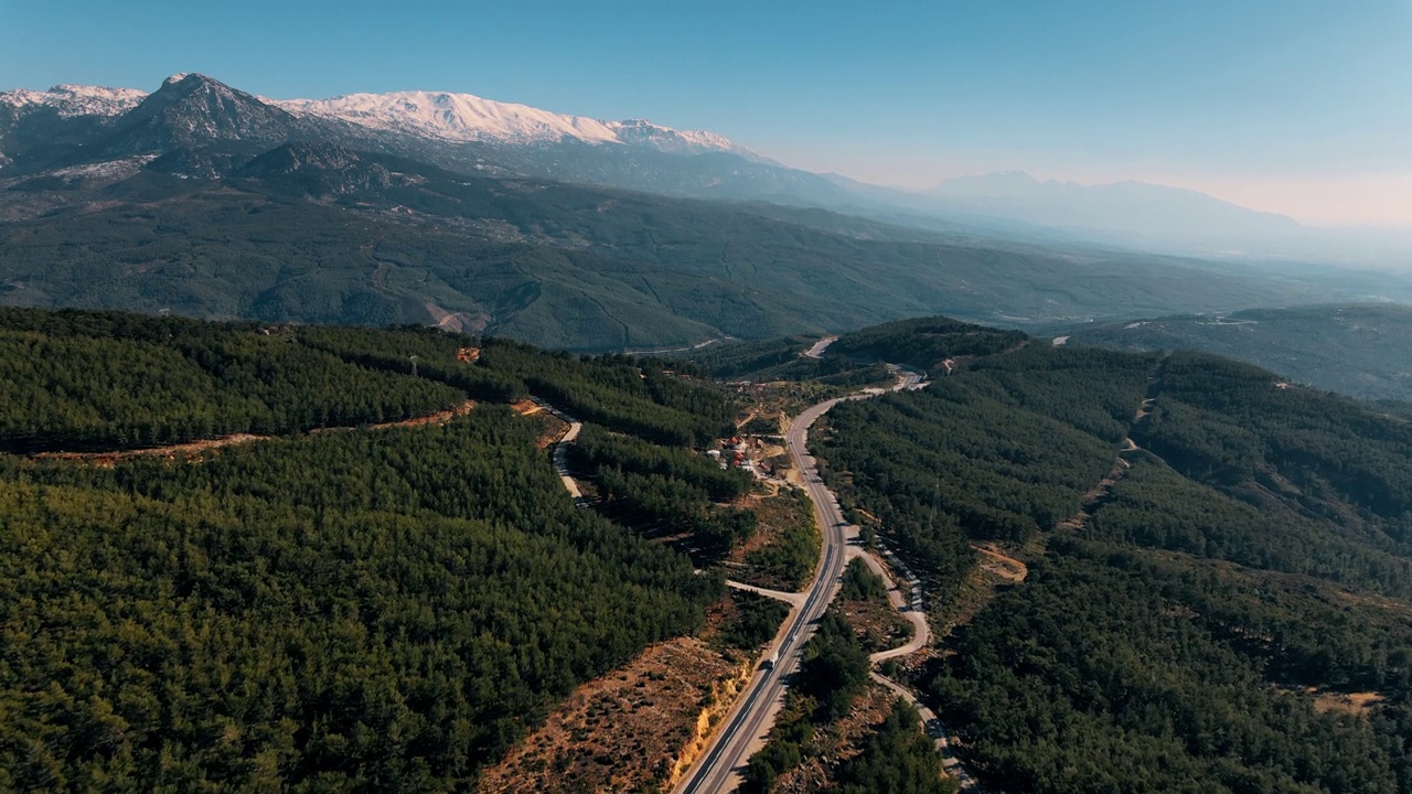 在山林中蜿蜒的道路上飞翔视频素材