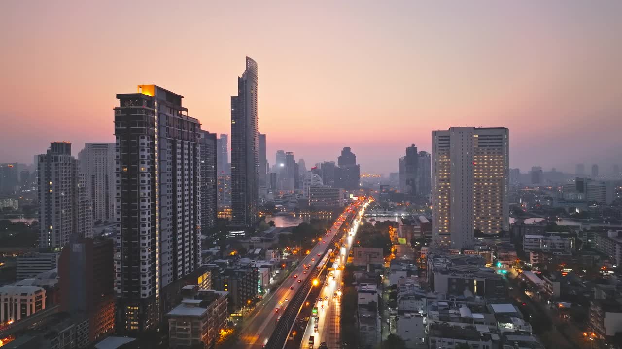 在曼谷的Chao Phaya河上，空中无人机观看高速公路和地铁空中列车上的交通运输日出。泰国曼谷商业区地标。视频素材