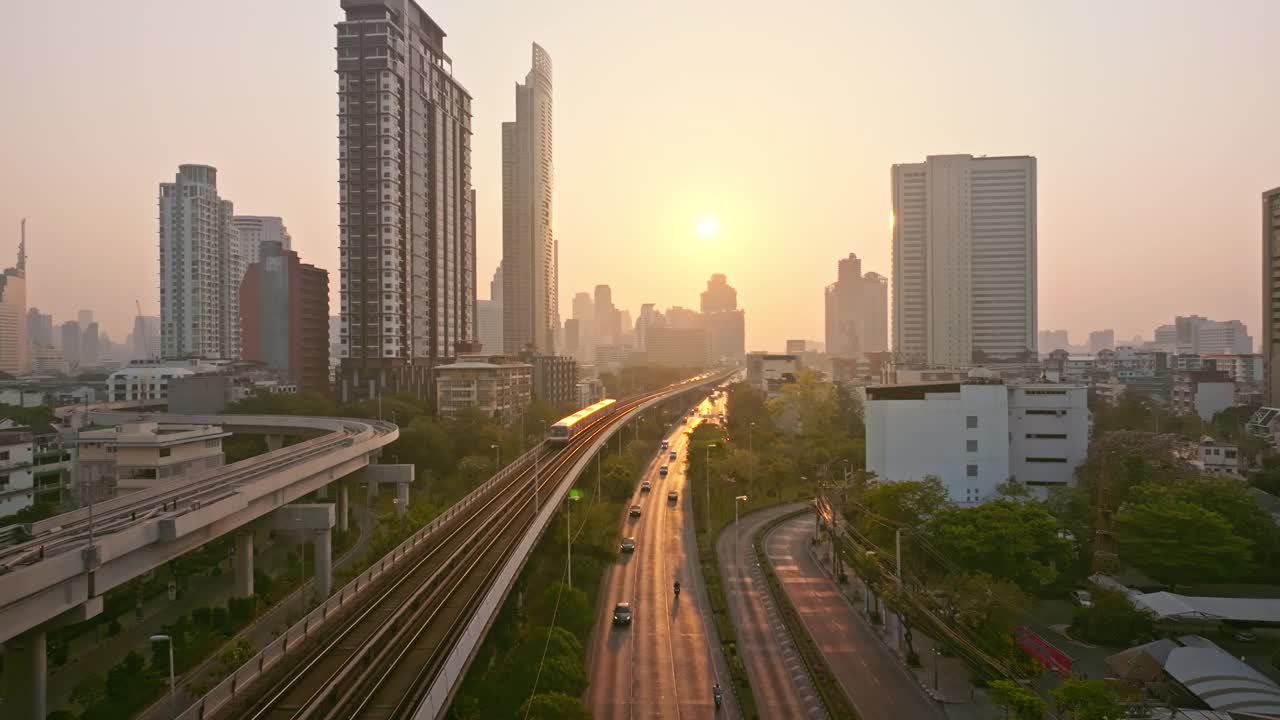 在曼谷的Chao Phaya河上，空中无人机观看高速公路和地铁空中列车上的交通运输日出。泰国曼谷商业区地标。视频素材