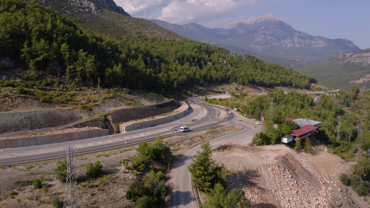 驾驶汽车通过森林山脉的道路鸟瞰图。视频素材