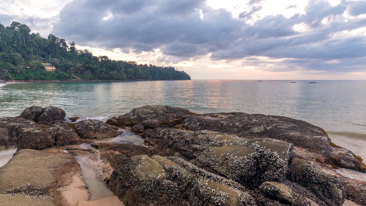 热带海滩日落与岩石海岸和海浪在考勒克，泰国攀牙的自然景观时间推移视频素材