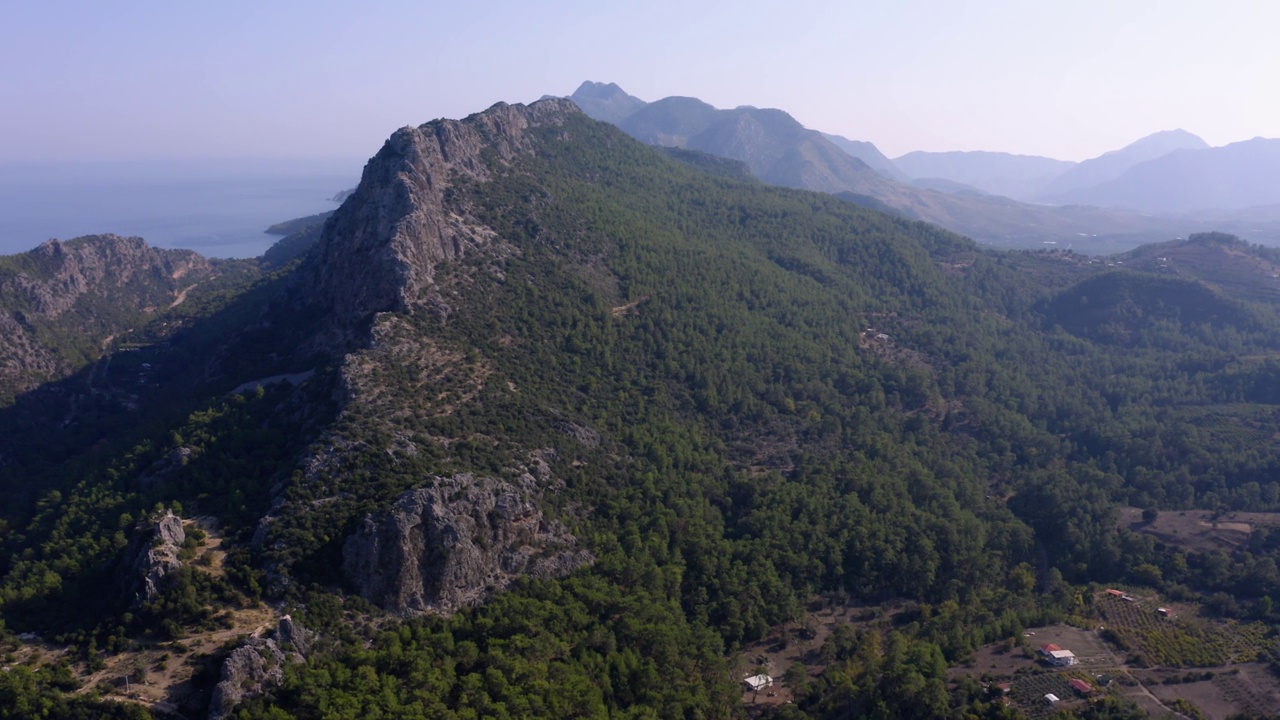 无人机鸟瞰覆盖着绿色森林的高山。视频素材