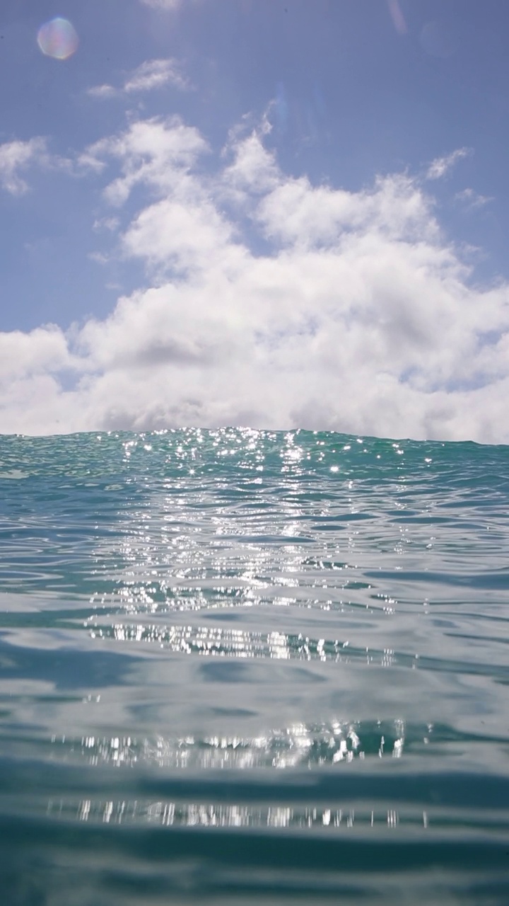 在阳光灿烂的日子里，海浪般的海景在多云的天空下的慢镜头——夏威夷的威基基视频素材