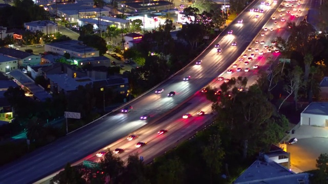 空中向后拍摄的照明汽车在城市的桥梁道路上移动在夜间-卡尔弗城，加利福尼亚视频素材