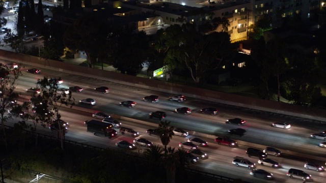 航拍:无人机拍摄的汽车在道路上移动的房屋在夜间城市-卡尔弗城，加利福尼亚视频素材