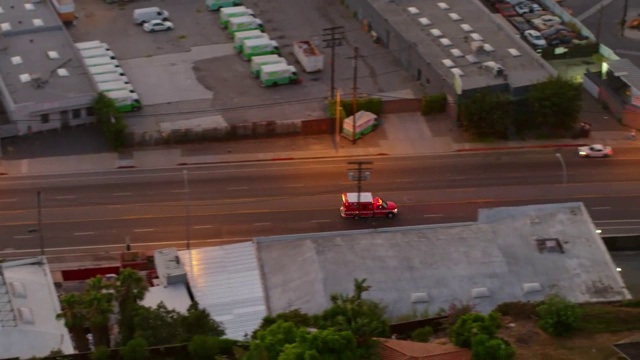 平移镜头的红色救护车移动在道路上的城市在黄昏-卡尔弗城，加利福尼亚视频素材